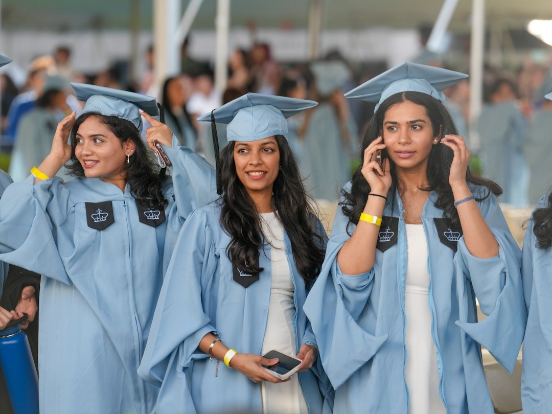 Graduates in light blue gowns celebrating at commencement